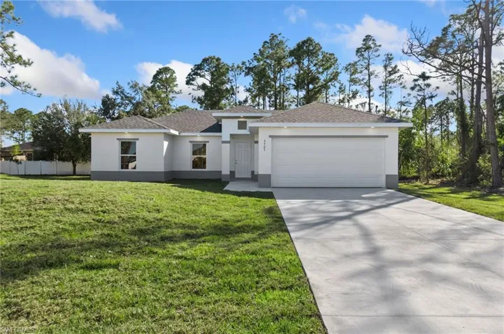 View of front of house featuring a front lawn and a garage