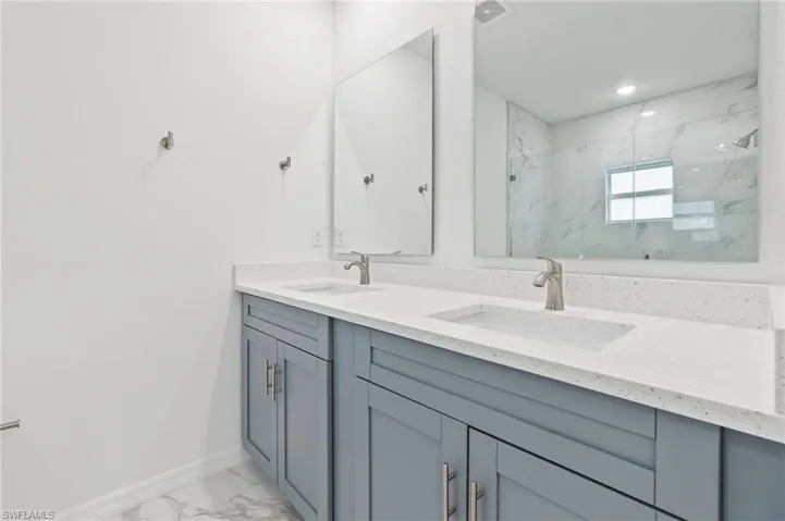 Bathroom with a shower with shower door and vanity