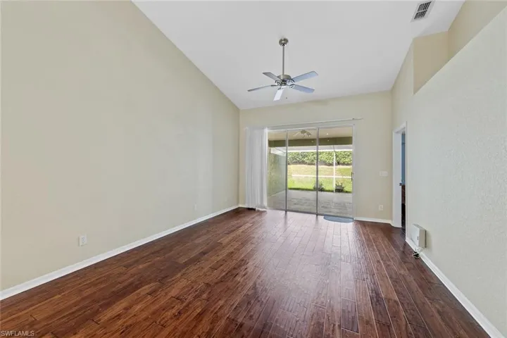 Empty room featuring dark hardwood / wood-style flooring and ceiling fan