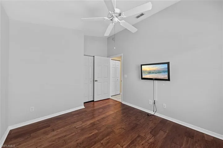 Unfurnished bedroom featuring high vaulted ceiling, hardwood / wood-style flooring, and ceiling fan