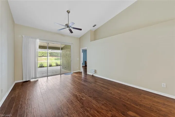 Unfurnished room featuring high vaulted ceiling, dark hardwood / wood-style flooring, and ceiling fan