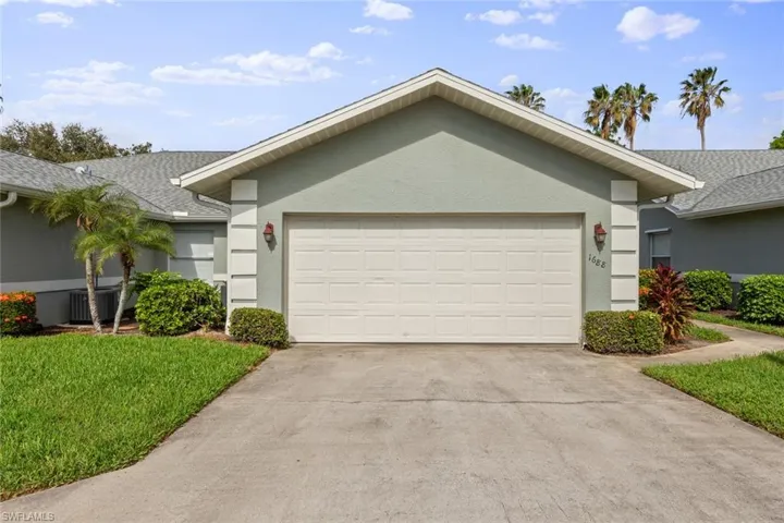Single story home featuring a garage and a front yard