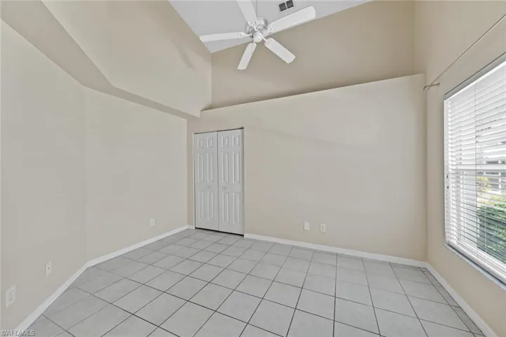 Empty room featuring ceiling fan, a healthy amount of sunlight, and light tile patterned floors