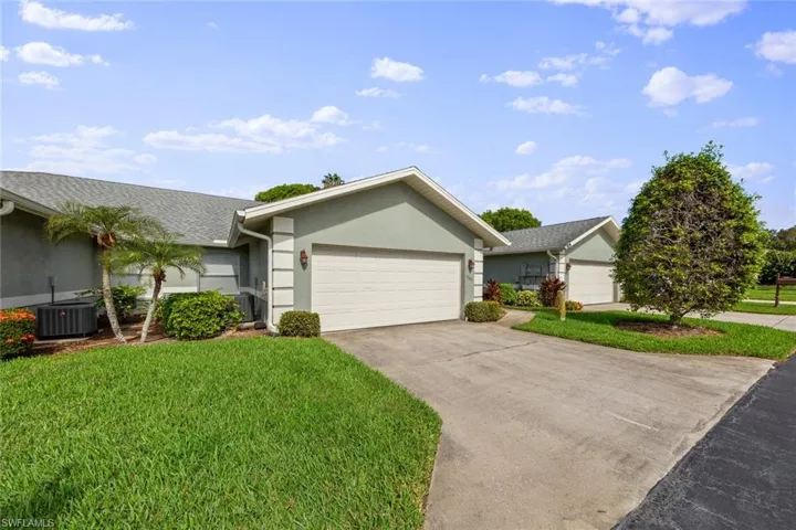 Ranch-style house featuring a garage, central AC, and a front yard