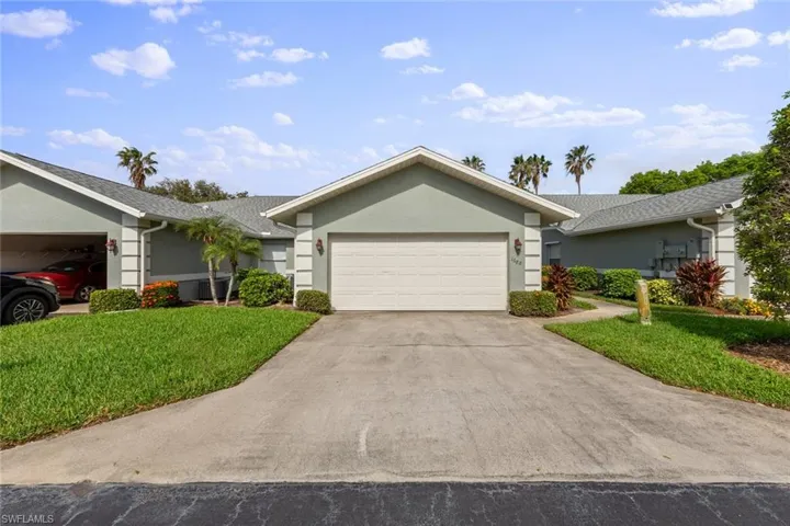Ranch-style house featuring a garage and a front yard