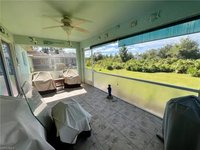 Screened lanai with a ceiling fan and tile floors.