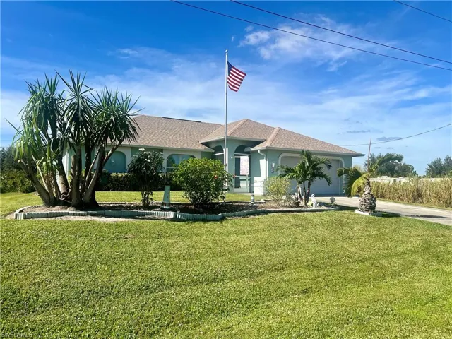 View of front of house featuring a nicely landscaped front lawn and a garage
