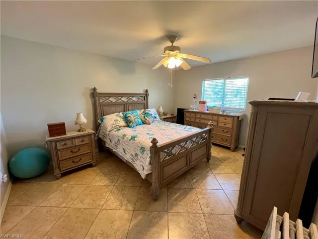 Primary bedroom with tile floors & ceiling fan