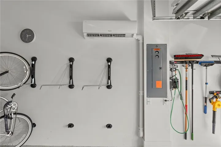 Utility room featuring electric panel and a wall mounted mini split New CUSTOM CALIFORNIA CLOSET ORGANIZERS (February 2020), New MINI-SPLIT AC (May 2020), New electrical panel SURGER PROTECTOR (October 2022), New GARAGE INTERIOR PAINT (July 2023)