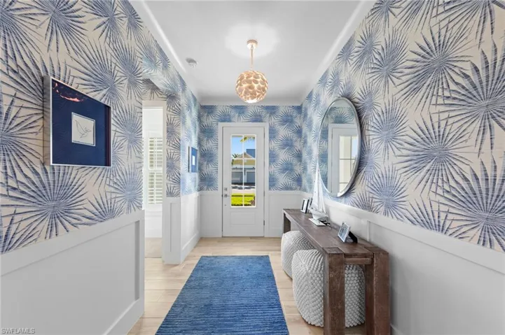 Entryway with wainscoting, wood finished floors, and wallpapered walls New CHANDELIER (November 2018), New WALLPAPER (June 2020)