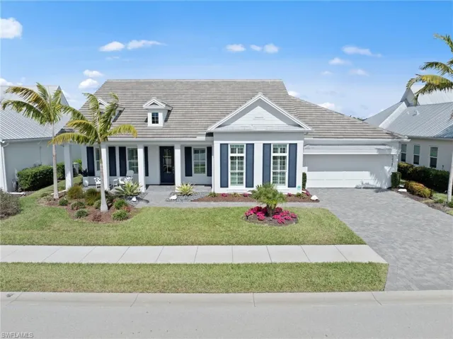 View of front facade featuring a front yard, a porch, driveway, an attached garage, and a tile roof New VIDEO DOORBELL (November 2018), ROOF POWER WASHED (December 2022), New LANDSCAPING (December 2025)