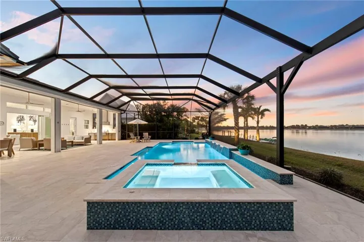 Pool at dusk with a water view, an outdoor living space, a lanai, a patio, and a sunroom New LANDSCAPE LIGHTING (February 2019)