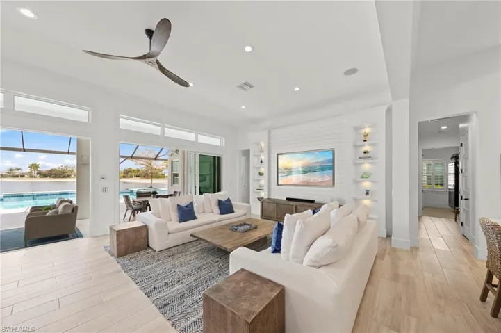 Living room with a sunroom, recessed lighting, light wood-type flooring, a ceiling fan, and built in features New MOUNTED TV & SONOS SOUND BAR (November 2018), New SHIPLAP BUILT-IN & WALLS (May 2020), New CEILING FAN (October 2024)