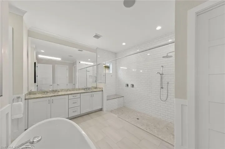 Bathroom with double vanity, a tile shower, a soaking tub, crown molding, and recessed lighting New CUSTOM MIRROR & SCONCES (February 2020), New WALLPAPER (June 2020), New PRIMARY BATH CEILING PAINT (July 2023)
