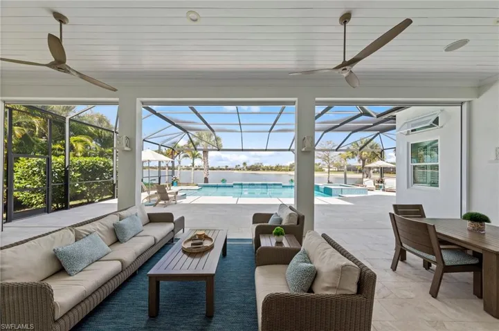 View of patio / terrace featuring a sunroom, outdoor lounge area, a lanai, ceiling fan, and a pool with connected hot tub New electric Storm Smart HURRICANE SHUTTERS (March 2019), New SHIPLAP CEILING & CROWN MOLDING (May 2020), New CEILING FAN (October 2024)