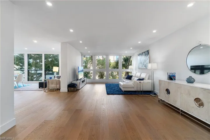 Living area featuring light wood-style floors, recessed lighting, and floor to ceiling windows
