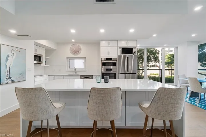 Kitchen featuring white cabinets, stainless steel appliances, light wood-type flooring, recessed lighting, and open shelves