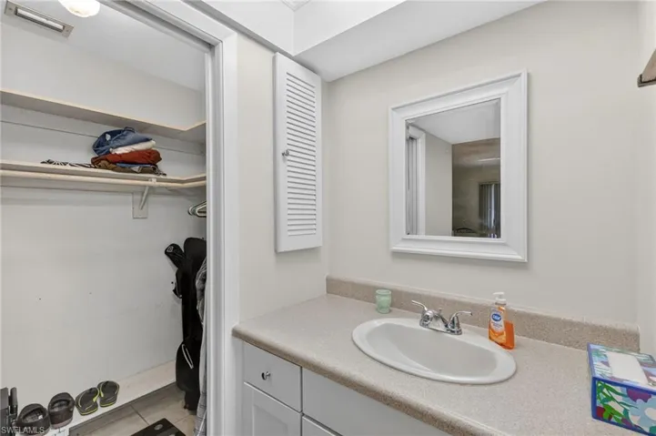 Bathroom vanity with a white framed mirror, oval undermount sink, and light-toned countertop