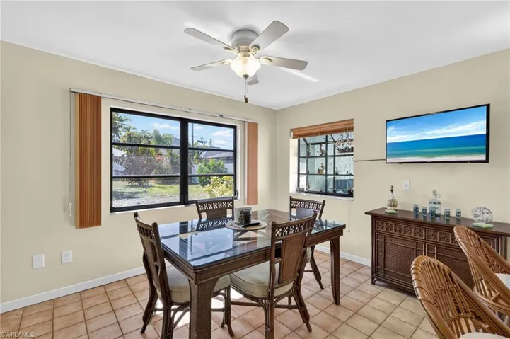 Spacious dining area featuring neutral wall tones, tile flooring, and a ceiling fan with integrated lighting