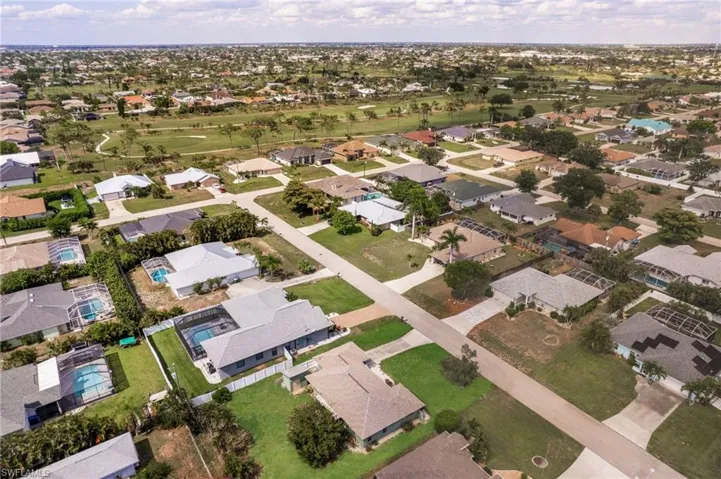 Residential neighborhood featuring single-story homes with shingled roofs and private swimming pools