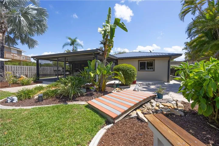 Rear view of house featuring a patio, stucco siding, and a metal roof
