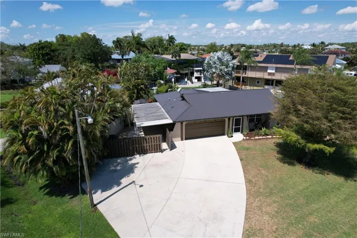 View of front of house with an attached garage, concrete driveway, and a metal roof