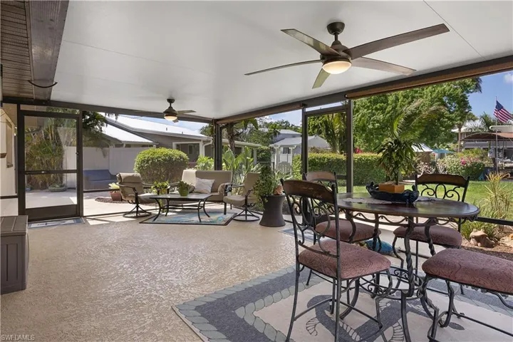 Sunroom with a ceiling fan, outdoor dining area, and a patio