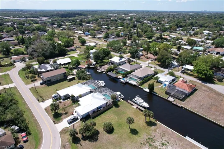 Aerial view of property and surrounding area with a nearby body of water and nearby suburban area