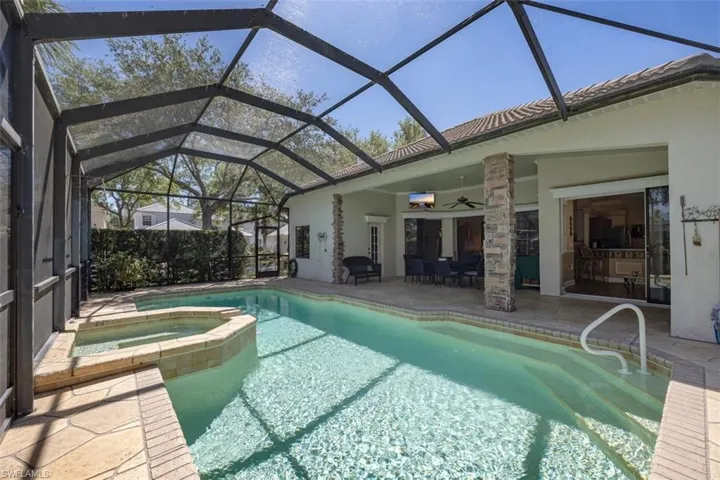 View of pool with ceiling fan, a pool with connected hot tub, and a patio
