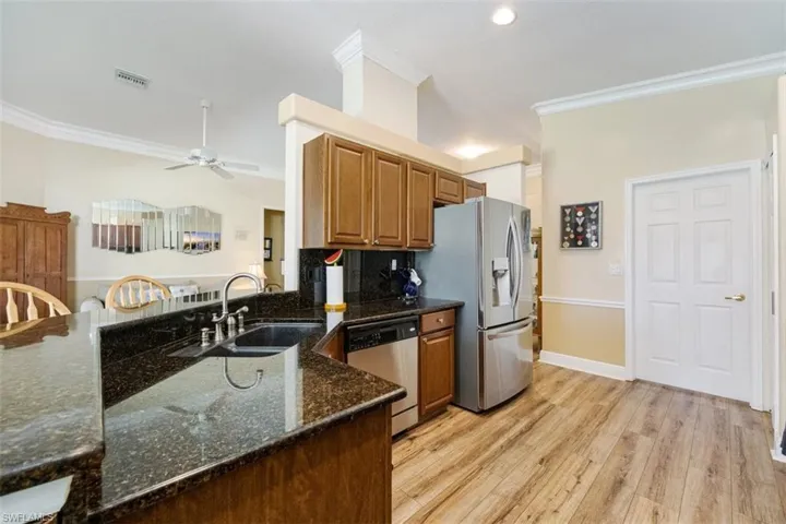 Kitchen with ornamental molding, stainless steel appliances, a sink, ceiling fan