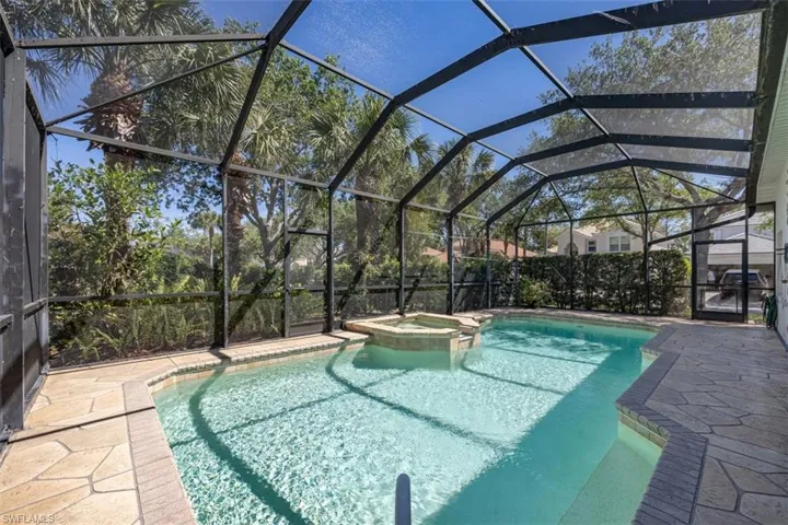 View of swimming pool featuring a patio, a pool with connected hot tub, and a lanai