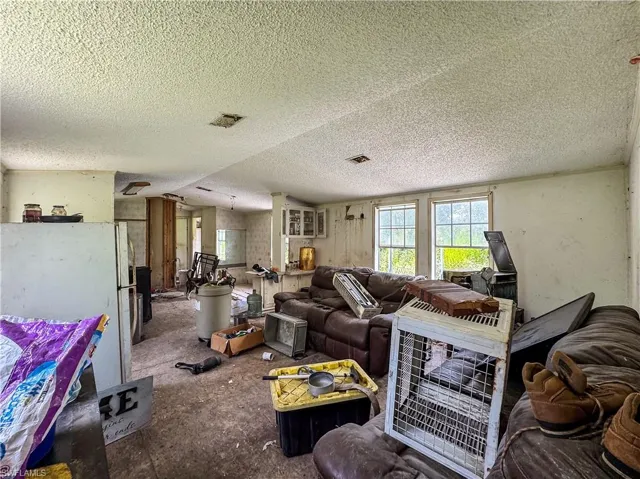 Living area with a textured ceiling and vaulted ceiling