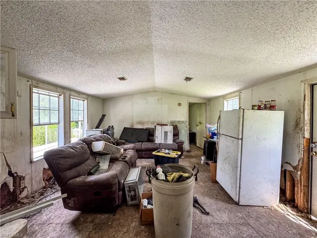 Living area with a textured ceiling and lofted ceiling