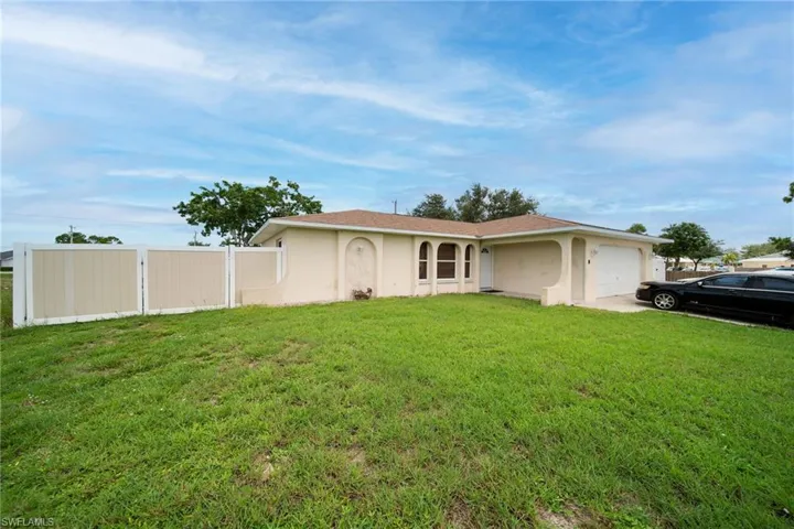 Ranch-style home featuring a garage and a front lawn