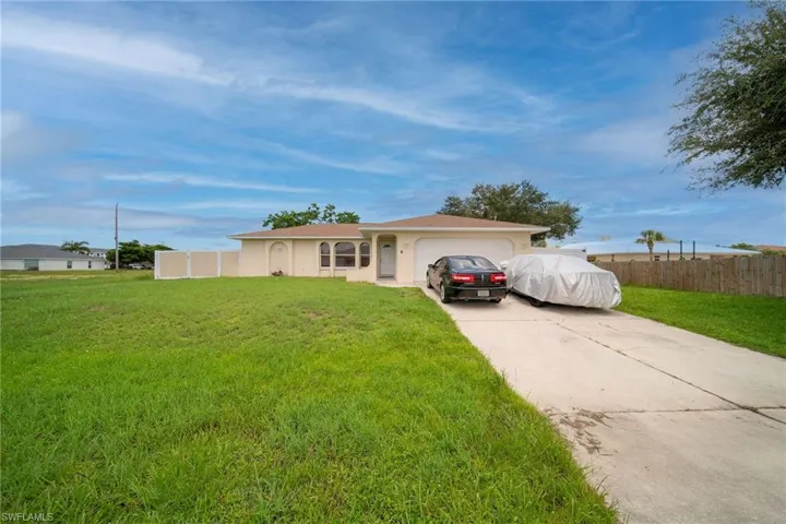 Single story home with a garage and a front lawn