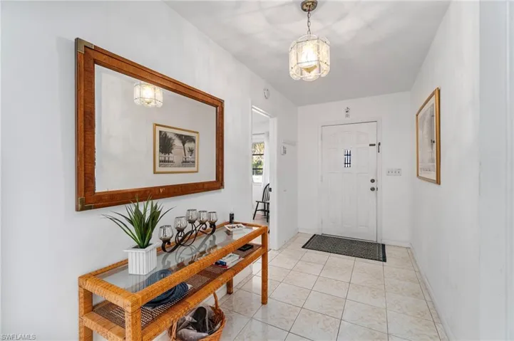 Foyer entrance with light tile patterned floors and baseboards