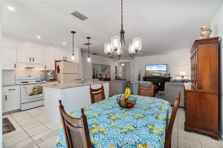 Dining space with a chandelier, light tile patterned floors, and recessed lighting