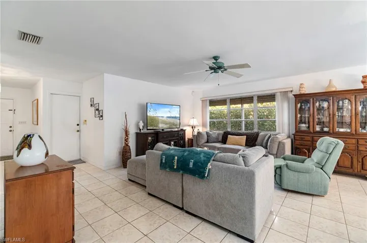 Living area featuring light tile patterned floors and a ceiling fan