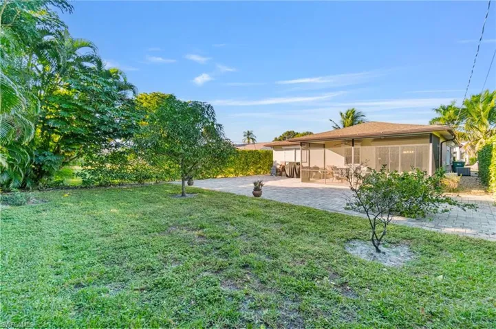 View of green lawn with a sunroom
