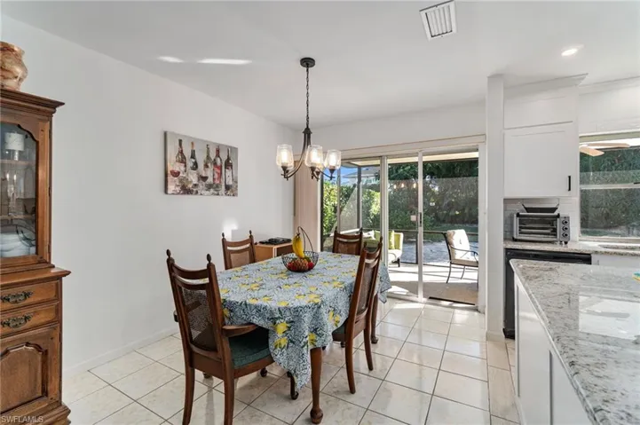 Dining space with light tile patterned floors, a chandelier, and recessed lighting