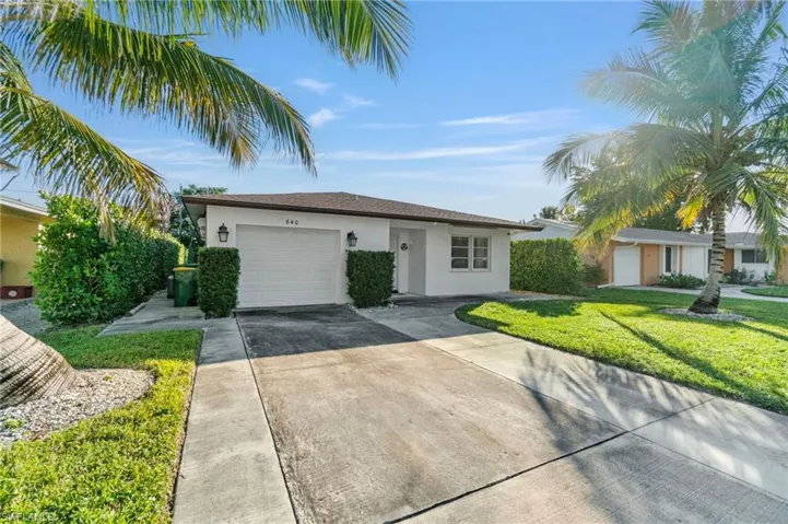 Single story home featuring stucco siding, an attached garage, driveway, and a front lawn