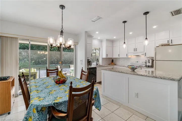 Dining space featuring a chandelier, light tile patterned floors, and recessed lighting