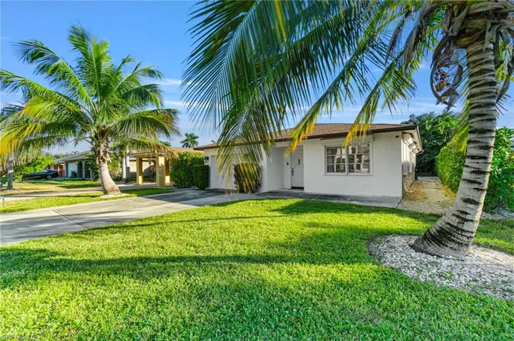 Ranch-style house with stucco siding, concrete driveway, and a front lawn