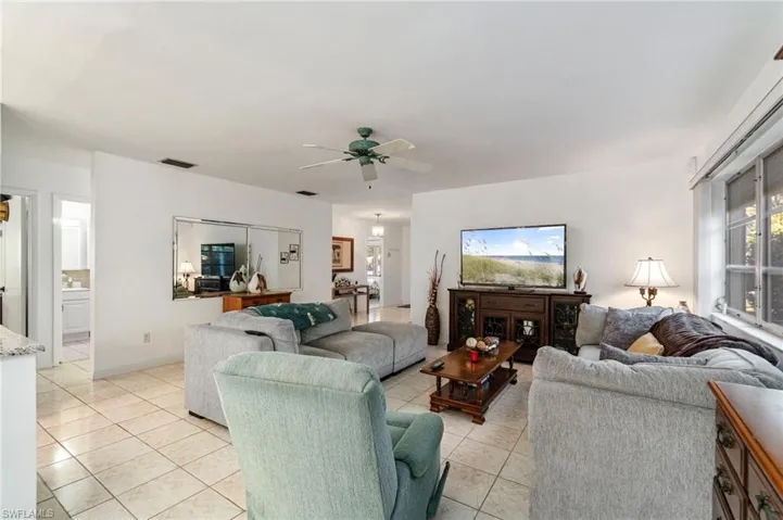 Living room featuring light tile patterned floors and ceiling fan