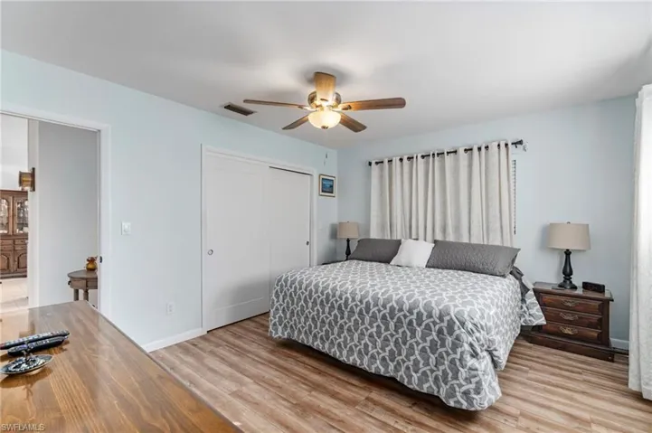 Bedroom with a closet, a ceiling fan, and light wood-style flooring