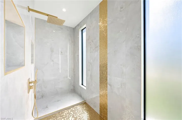 Full bath with a marble finish shower and visible vents