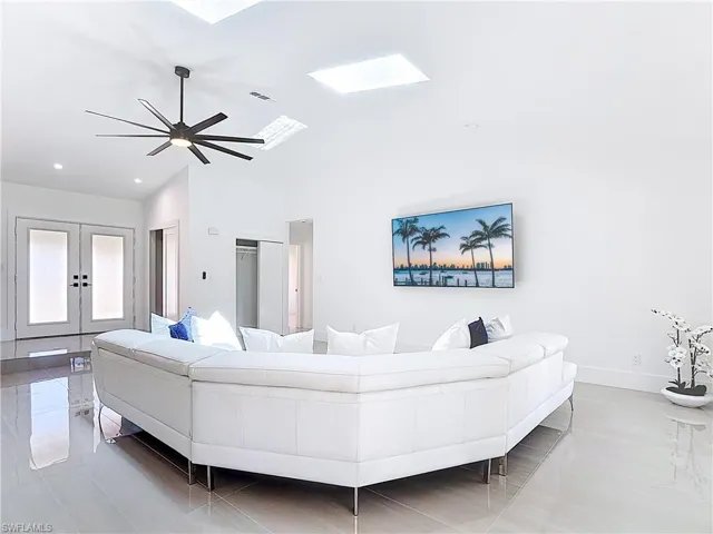Living room with french doors, vaulted ceiling, a skylight, ceiling fan, and recessed lighting