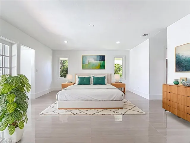 Virtually staged master bedroom with recessed lighting and light wood-style floors