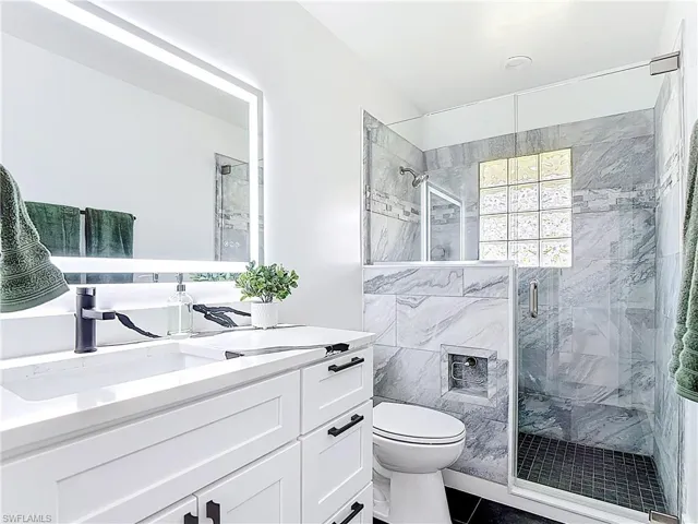 Bathroom featuring vanity, a stall shower, and tile patterned flooring