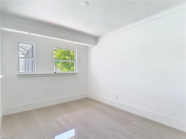 Empty room with crown molding and a textured ceiling